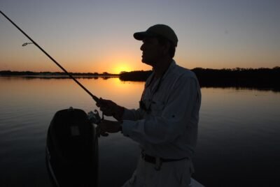 Pêcheur combattant un brochet avec une canne spinning et de la tresse